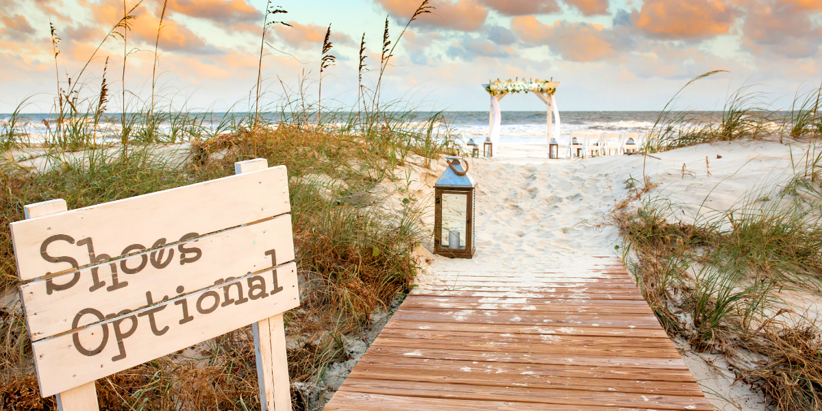 Boardwalk to beach with wedding arch and seating in background