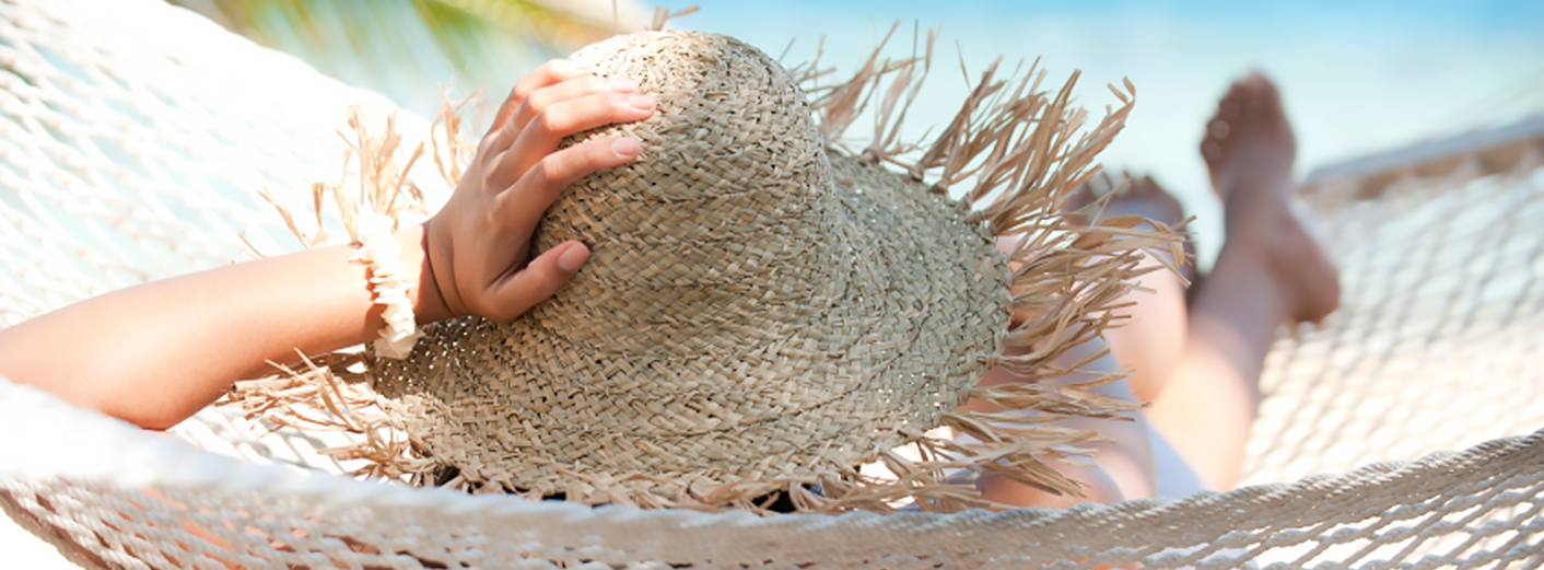 Woman in hammock relaxing near the beach.