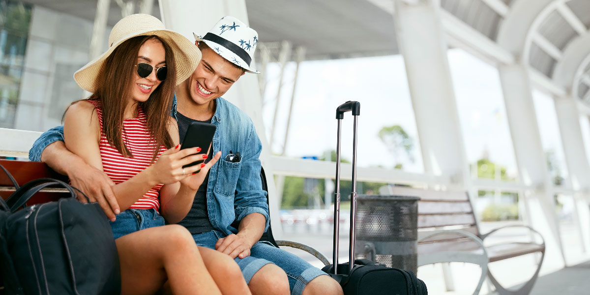 Couple in airport making plans on a phone.