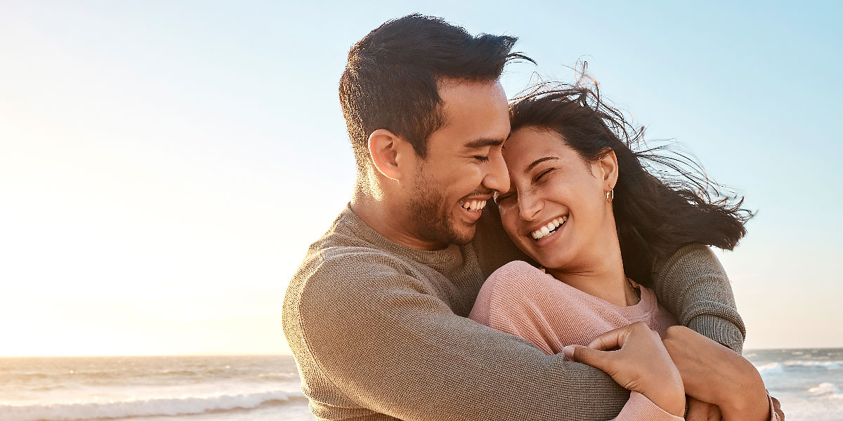 Happy couple hugging on beach