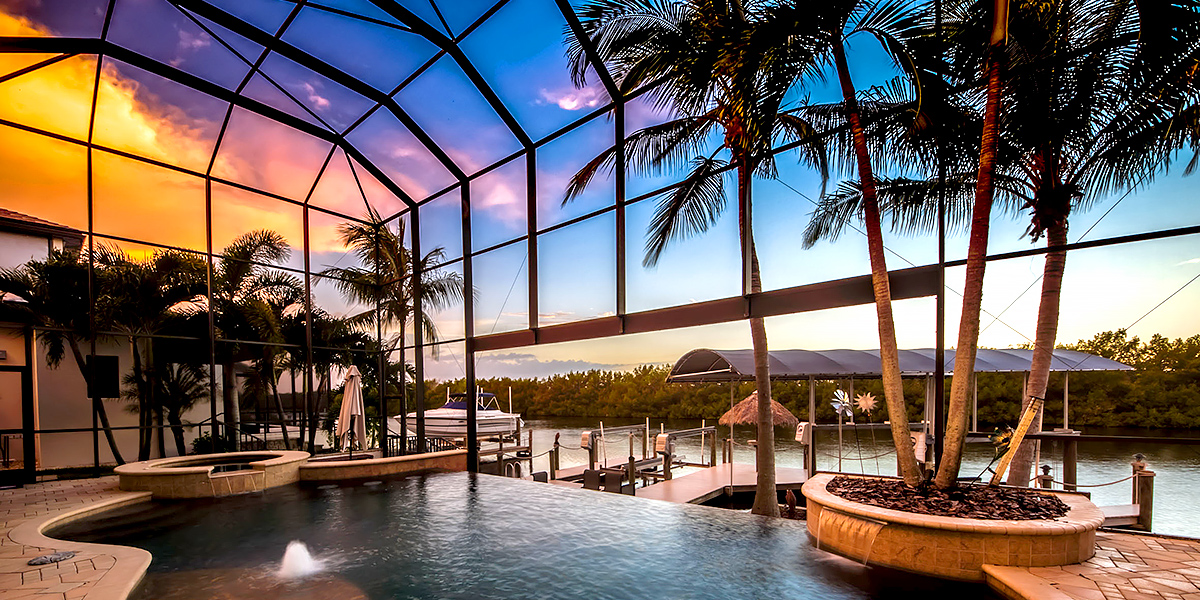 Sunset view over canal from a huge lanai with negative edge pool.